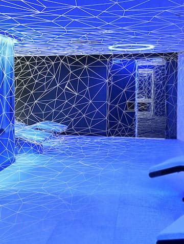 A living space with furniture, blue lighting and wireframe effects