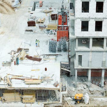 Two construction workers standing on an unfinished bulding